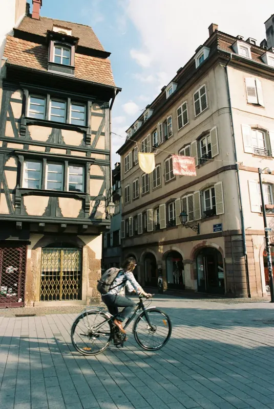 Une cycliste passe devant les maisons à colombages de Strasbourg